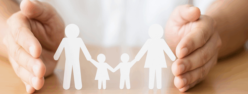 Twee handen met daartussen geknipte papieren poppetjes van een man, vrouw en twee kinderen